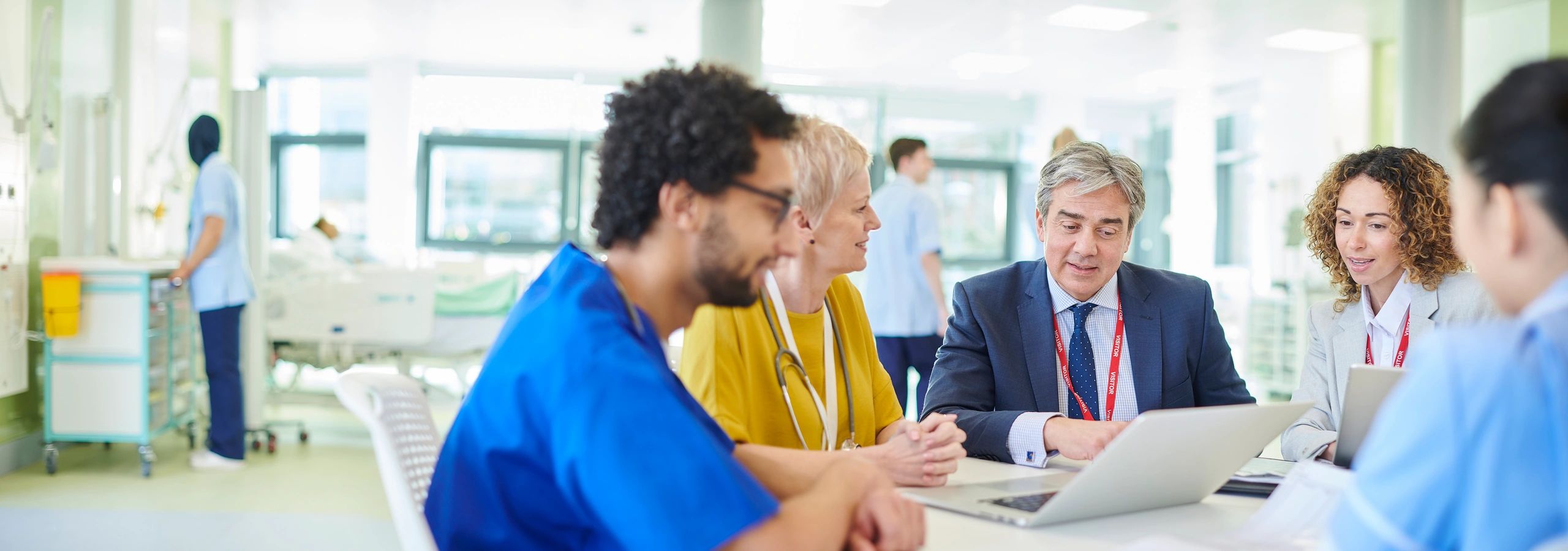 Healthcare leaders meeting in a busy hospital
