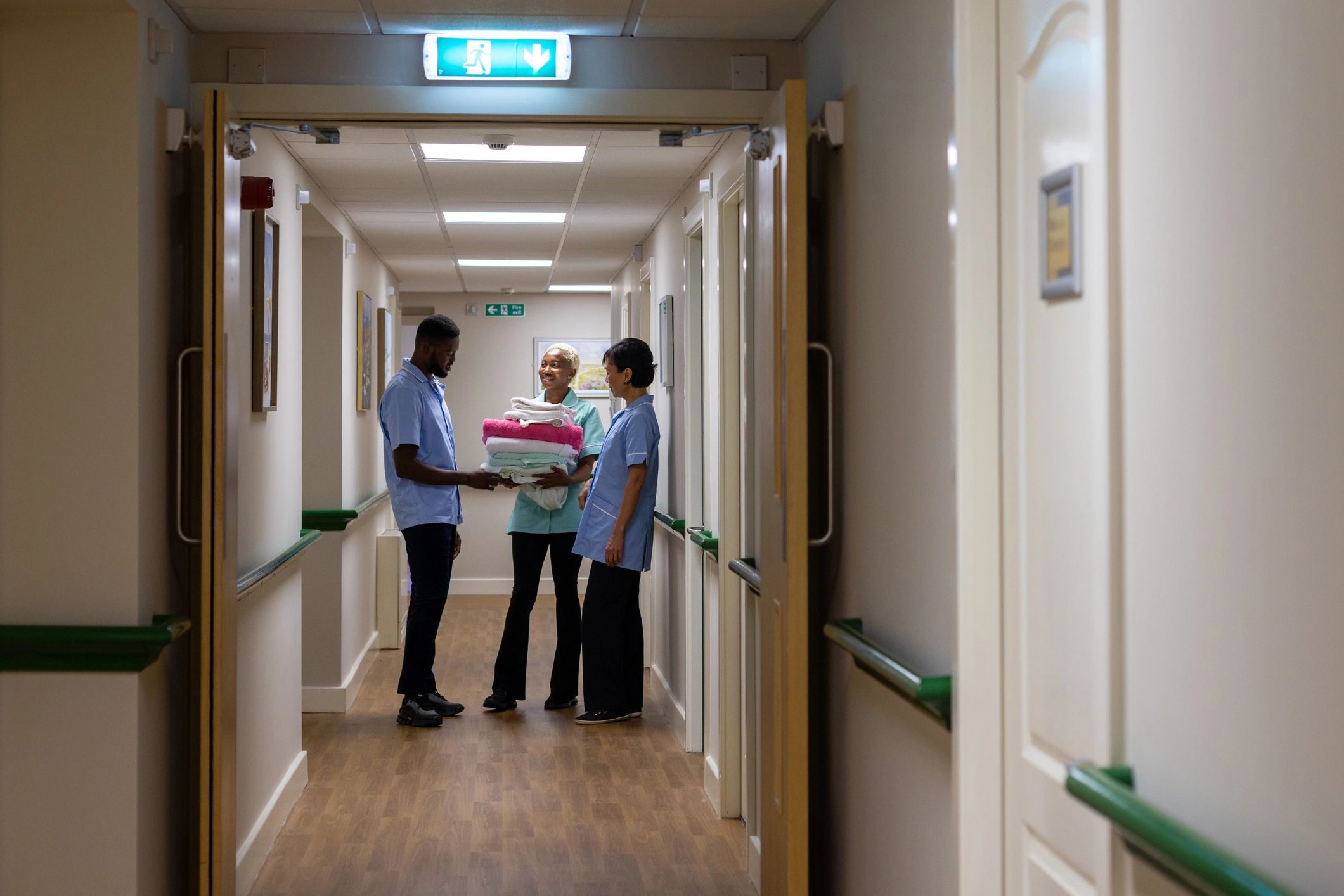 Healthcare workers talking together in a care corridor